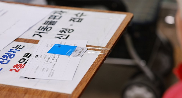 고유가 피해지원금 1차 지급이 시작된 지난 27일 오전 인천시 미추홀구 용현5동 행정복지센터에서 신청자가 지원금이 담긴 선불카드를 받고 있다. 연합뉴스