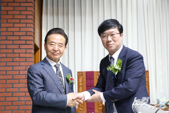김승규 원로목사와 유한수 담임목사가 위임예배 후 악수하며 축하와 격려를 나누고 있다. 최화랑 기자