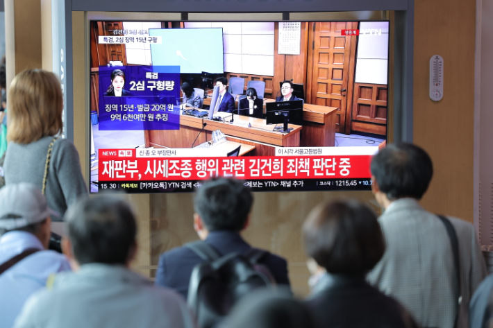 28일 서울역 대합실에서 시민들이 통일교 금품 수수와 도이치모터스 주가조작, 명태균 무상 여론조사 등의 혐의를 받는 김건희 여사에 대한 항소심 선고공판 생중계를 보고 있다. 연합뉴스