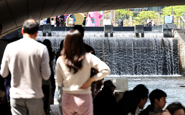 서울 낮 최고 기온이 28도까지 오르면서 6월 중하순에 해당하는 여름 더위가 나타난 지난 14일 서울 중구 청계천을 찾은 시민들이 산책을 하고 있다. 황진환 기자