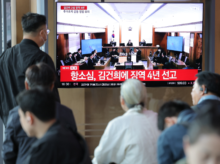 28일 서울역 대합실에서 시민들이 통일교 금품 수수와 도이치모터스 주가조작, 명태균 무상 여론조사 등의 혐의를 받는 김건희 여사 항소심 선고공판 생중계를 시청하고 있다. 연합뉴스