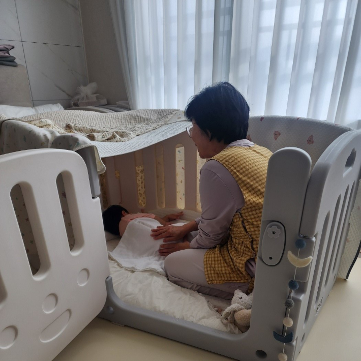 아이돌봄 서비스의 일환으로 아이돌보미가 가정을 방문해 영아를 돌보고 있다. 밀양시 제공