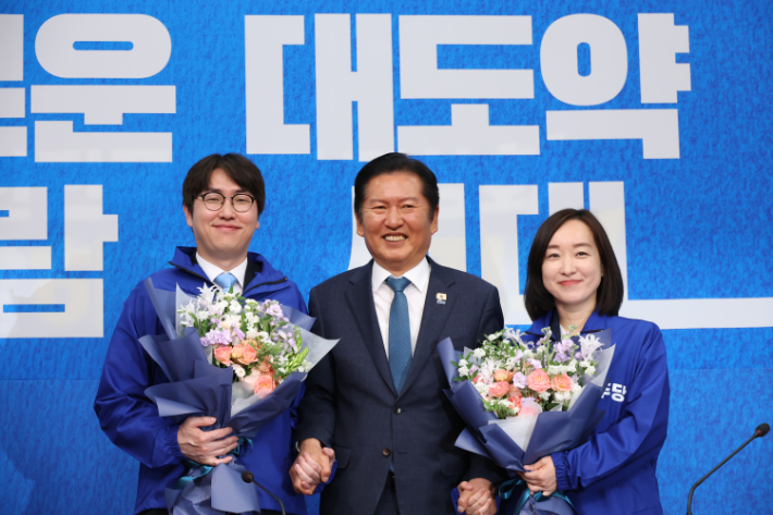 6·3 재보선에 격전지로 떠오른 부산 북구 갑 지역구에 출마할 것으로 예상되는 하정우 전 청와대 AI수석과 아산을에 출마할 것으로 보이는 전은수 전 청와대 대변인이 29일 국회에서 열린 더불어민주당 인재 영입식에서 꽃다발을 들고 더불어민주당 정청래 대표와 기념 촬영하고 있다. 연합뉴스