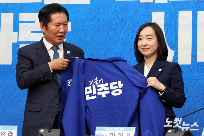 더불어민주당 정청래 대표가 29일 서울 여의도 국회에서 열린 2차 인재영입식에서 전은수 전 청와대 대변인에게 당 점퍼를 전달하고 있다.