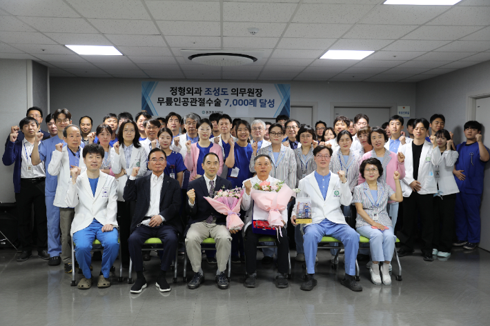 박원희 동강의료재단 이사장과 조성도 동천동강병원 의무원장 등 병원 관계자들이 조 의무원장의 무릎 인공관절수술 7천례 달성을 축하하며 기념촬영을 하고 있다. 동천동강병원 제공