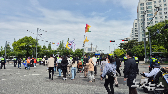 29일 오전 10시 40분쯤 장애인단체 회원들이 광주 서구 무진대로 사거리를 가로질러 행진하고 있다. 한아름 기자