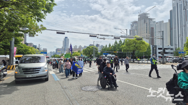 29일 오전 10시 40분쯤 장애인단체 회원들이 광주 서구 무진대로 사거리를 가로질러 행진하고 있다. 한아름 기자