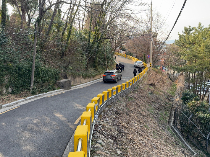 부산의 한 학교 통학로에 보도와 차도 구분이 없어 학생과 차량이 함께 다니고 있다. 부산시 제공