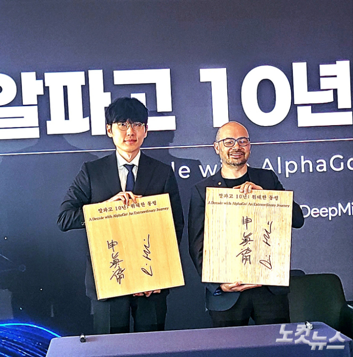 신진서 9단(사진 왼쪽)과 데미스 하사비스가 친필 사인을 한 바둑판을 들어보이고 있다. 동규기자