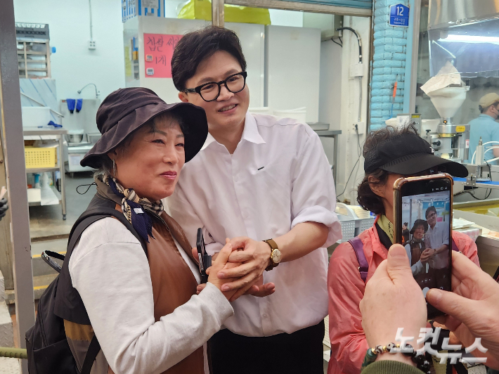 29일 부산 북구 구포시장을 찾은 한동훈 전 국민의힘 대표가 시민들과 사진을 찍고 있다. '한동훈 효과'로 서부산 보수 표심이 결집해 국민의힘 후보에게 반사이익을 미칠지 주목되고 있다. 정혜린 기자