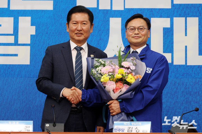 더불어민주당 정청래 대표가 30일 서울 여의도 국회에서 열린 3차 인재영입식에서 김성범 전 해양수산부 차관에서 당점퍼를 전달하고 기념촬영을 하고 있다.