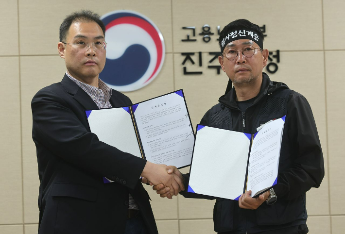 이민재 BGF로지스 대표이사(왼쪽)와 김동국 화물연대 위원장이 합의안을 들고 기념 촬영을 하고 있다. 연합뉴스