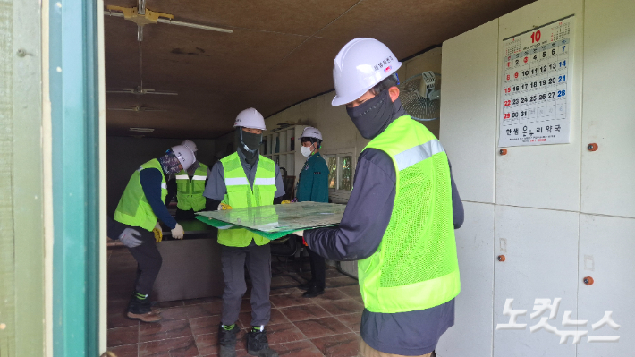 30일 오전 10시쯤 철거업체 작업자들이 영산강 변에 불법으로 설치된 조립식 건물 내부의 집기류를 수거하고 있다. 한아름 기자