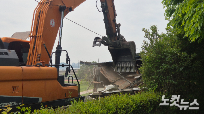 30일 오전 11시쯤 철거업체 작업자가 굴삭기를 이용해 영산강 변에 불법으로 설치된 조립식 건물을 해체하고 있다. 한아름 기자