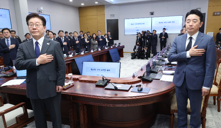 이재명 대통령이 30일 청와대에서 열린 수석보좌관회의에서 국기에 경례하고 있다. 오른쪽은 강훈식 비서실장. 연합뉴스