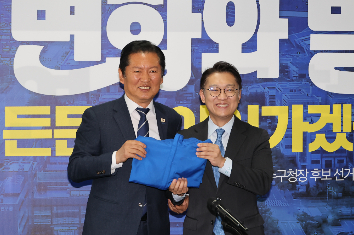  더불어민주당 정청래 대표가 24일 인천 연수구 정지열 인천 연수구청장 후보 선거사무소에서 열린 최고위원회의에서 김남준 계양을 보궐선거 후보에게 당 점퍼를 전달하고 있다. 연합뉴스