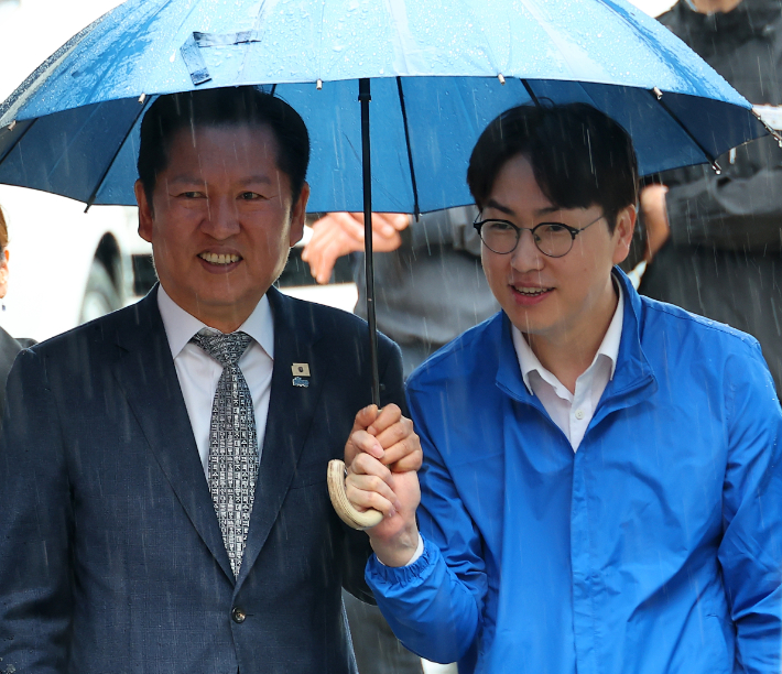 3일 부산 북구 구포시장에서 더불어민주당 정청래 대표와 북갑 국회의원 보궐선거 출마를 공식화한 하정우 전 청와대 AI 미래기획수석이 우산을 쓰고 이동하고 있다. 연합뉴스