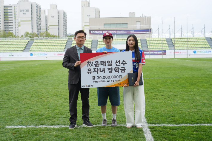 故윤태일 선수 유가족에게 장학금을 전달한 OK 읏맨 럭비단 권철근 단장. OK 읏맨 럭비단 제공