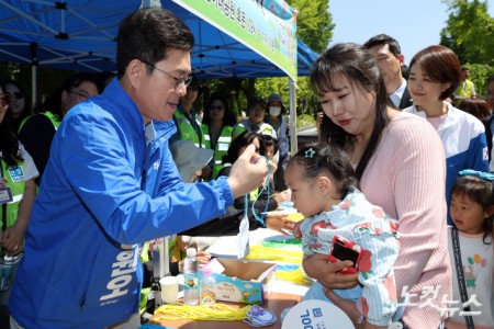 더불어민주당 정원오 서울시장 후보가 어린이날인 5일 서울 광진구 어린이대공원을 찾아 어린이에게 명찰을 만들어 목에 걸어주고 있다.