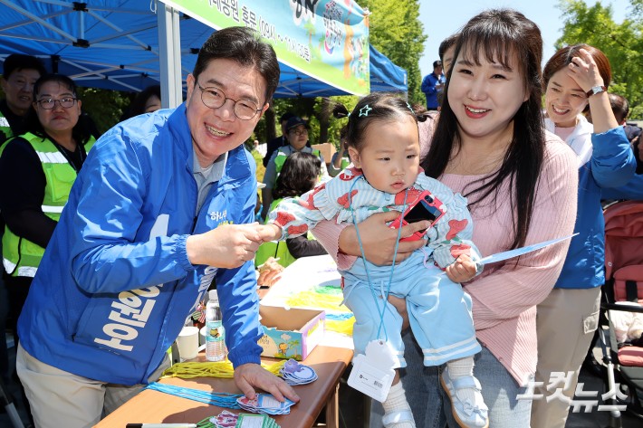 더불어민주당 정원오 서울시장 후보가 어린이날인 5일 서울 광진구 어린이대공원을 찾아 어린이에게 명찰을 만들어 목에 걸어주고 있다.