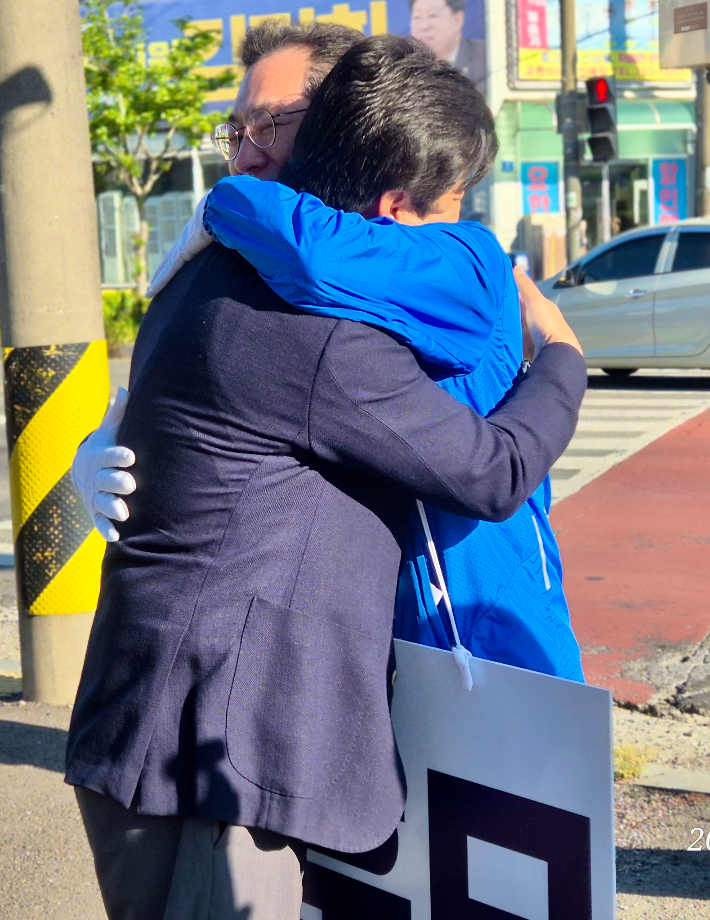 오하근 후보(좌측)와 손훈모 후보가 선거운동 중인 거리에서 포옹하고 있다. 손훈모 후보 제공
