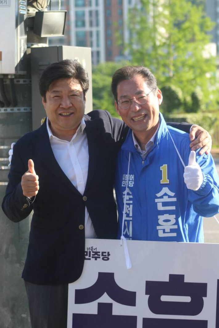 오하근 후보와 손훈모 후보가 어깨동무하며 엄지손가락을 치켜세우고 있다. 손훈모 후보 제공