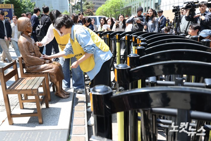 평화의 소녀상을 둘러싼 경찰 바리케이드가 6년 만에 전면 철거된 6일 서울 종로구 옛 주한 일본대사관 앞 평화의 소녀상에서 정의연 관계자가 제1751차 정기 수요시위를 시작하기 전 소녀상을 닦고 있다.경찰은 2020년 6월, 위안부 반대 단체 집회로 훼손 우려가 제기되자 소녀상 주변에 바리케이드를 설치했다. 하지만 지난 3월, 위안부법폐지국민행동 김병헌 대표가 사자명예훼손 혐의 등으로 구속되면서 철거 논의가 본격화됐다.