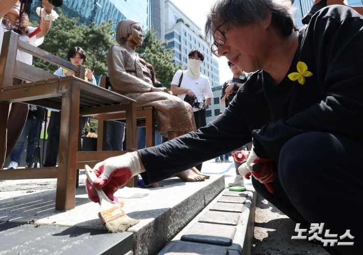 평화의 소녀상을 둘러싼 경찰 바리케이드가 6년 만에 전면 철거된 6일 서울 종로구 옛 주한 일본대사관 앞 평화의 소녀상에서 소녀상 제작자인 김서경·김운성 작가와 관계자들이 보수 작업을 하고 있다.