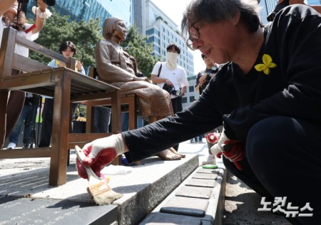 평화의 소녀상을 둘러싼 경찰 바리케이드가 6년 만에 전면 철거된 6일 서울 종로구 옛 주한 일본대사관 앞 평화의 소녀상에서 소녀상 제작자인 김서경·김운성 작가와 관계자들이 보수 작업을 하고 있다.