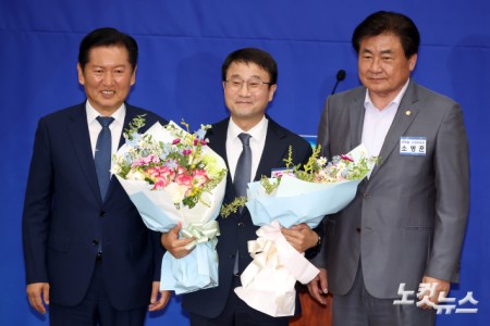 더불어민주당 새 원내대표로 선출되며 연임에 성공한 한병도 의원이 일 서울 여의도 국회에서 열린 원내대표 선출을 위한 의원총회에서 꽃다발을 받아들고 기념촬영을 하고 있다.