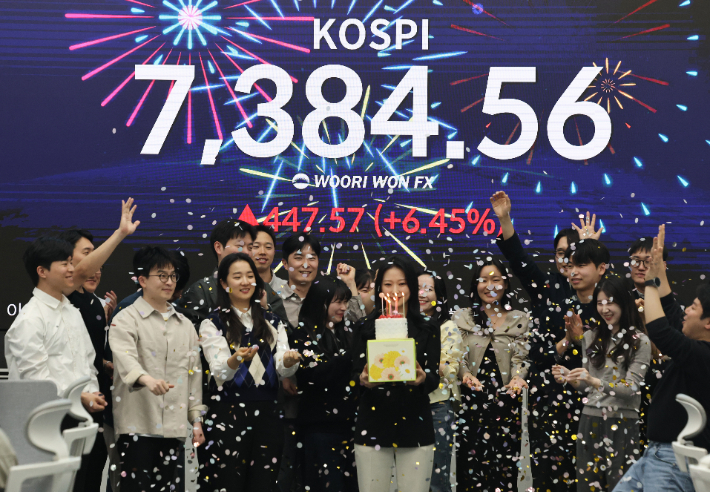코스피가 사상 처음으로 종가 기준 7천선을 돌파하며 장을 마친 6일 오후 서울 중구 우리은행 본점 딜링룸에서 직원들이 케이크를 들고 축하 세리머니를 하고 있다. 연합뉴스