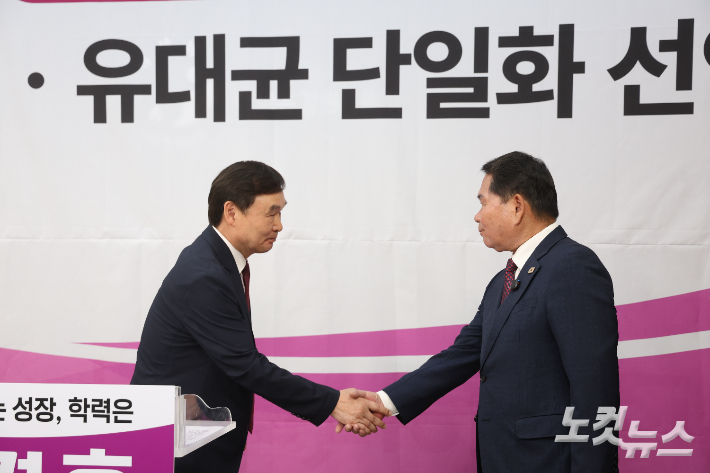 악수하는 유대균 강원교육감 선거 예비후보와 신경호 예비후보. 구본호 기자