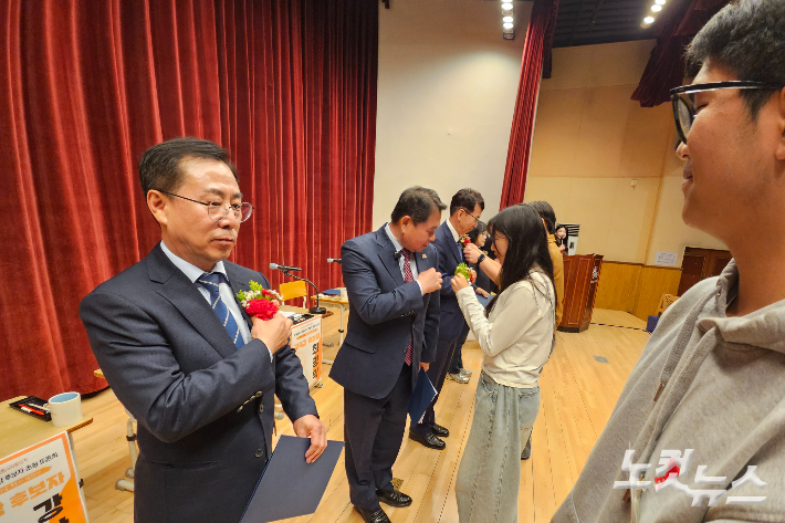 9일 강원CBS와 한국YMCA강원도협의회 주최로 열린 '청소년이 묻고, 교육감 후보가 답하다 - 강원특별자치도 교육감 후보자 초청토론회'에서 토론에 참석한 청소년들이 각 후보자들에게 카네이션을 달아주는 모습. 구본호 기자