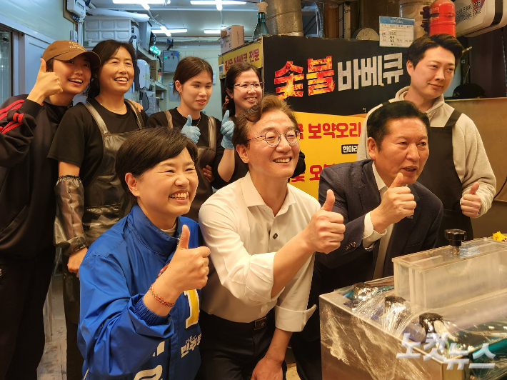 서은숙 더불어민주당 부산진구청장 후보가 전재수 부산시장 후보, 정청래 당대표가 부전시장을 찾아 상인들과 사진을 찍고 있다. 정혜린 기자