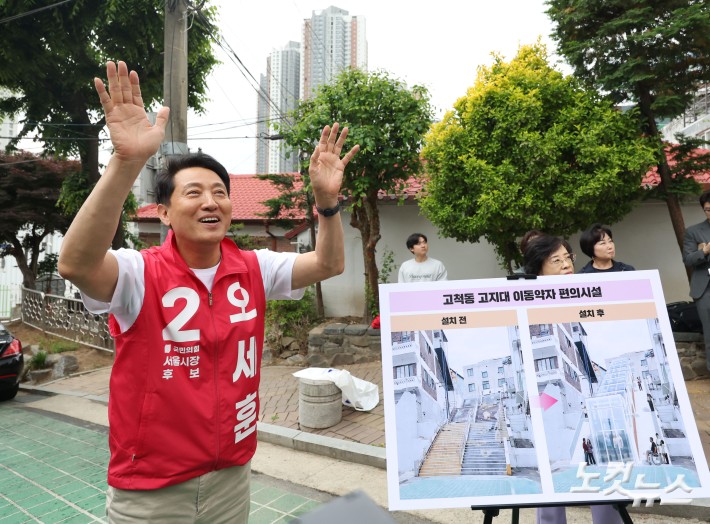 오세훈 국민의힘 서울시장 후보가 11일 오후 서울 구로구 고척동 고지대 이동약자 편의시설 설치 대상지를 방문해 주민들과 인사를 하고 있다.