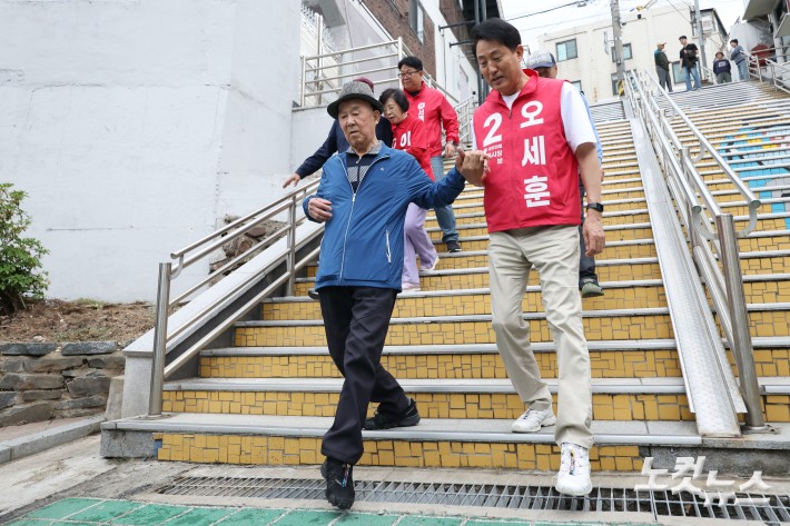 오세훈 국민의힘 서울시장 후보가 11일 오후 서울 구로구 고척동 주택가를 방문해 고지대 이동약자 편의시설 관련 브리핑을 받은 후 어르신들과 계단을 내려오고 있다.