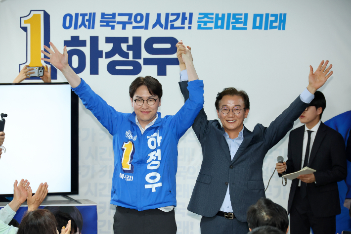  부산 북갑 국회의원 보궐선거에 출마하는 더불어민주당 하정우 후보가 10일 오후 부산 북구에서 열린 선거사무소 개소식에서 전재수 부산시장 후보와 손을 잡고 있다. 연합뉴스