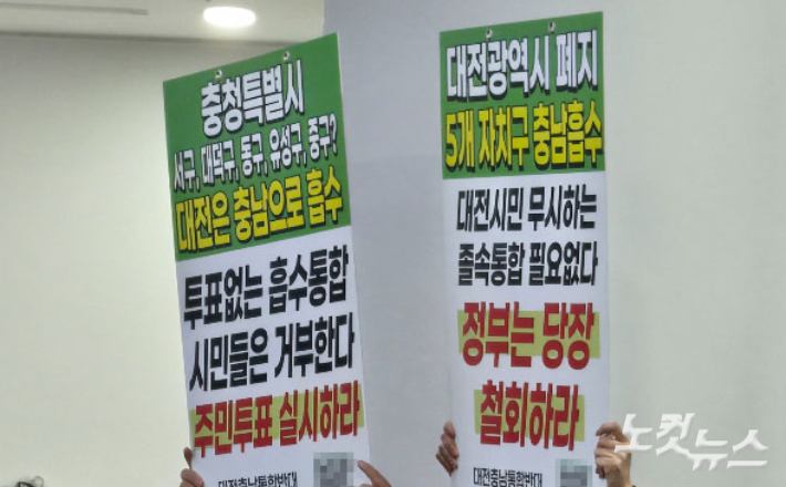 올해 1월 열린 대전시의회·충남도의회 의장 공동 기자회견에서 자리에 시민들이 통합 반대와 주민투표를 주장하는 피켓(글판 시위)을 들고 있다. 고형석 기자