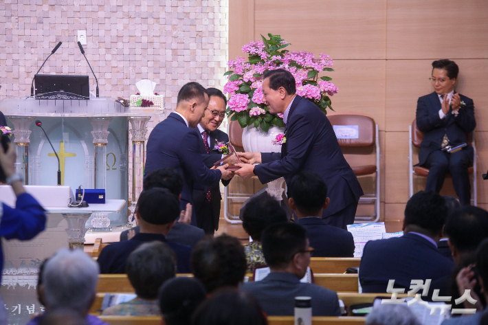 전북동지방회장 이순근 목사가 성전 헌당을 기념해 두명균 목사에게 축하패를 전달하고 있다. 최화랑 기자