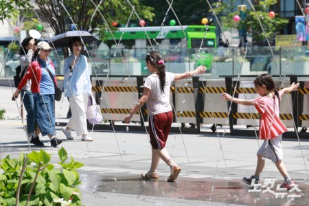 초여름 날씨를 보인 13일 서울 종로구 광화문광장 바닥 분수를 찾은 외국인 관광객들이 더위를 식히고 있다.
