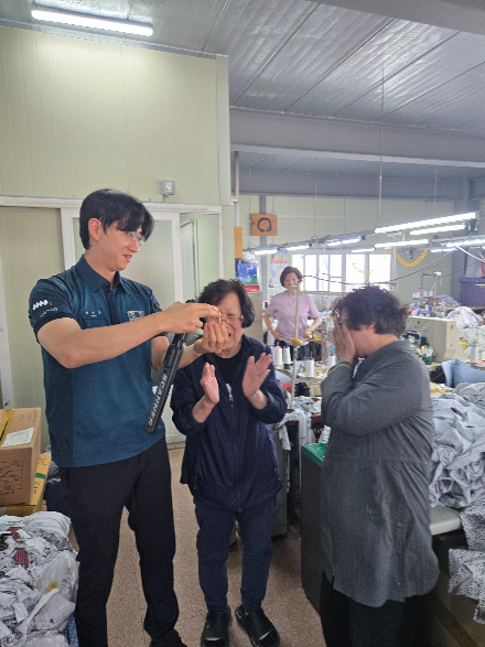 경찰관이 금팔찌를 찾아내자 기뻐하는 신고자들. 부산 연제경찰서 제공