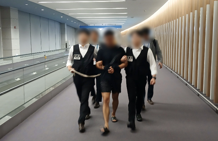 지난해 8월 법무부 관계자들이 그룹 방탄소년단(BTS) 정국을 포함한 국내 재력가들의 명의를 도용해 거액을 빼돌린 해킹조직 총책급 범죄인 중국 국적 전모(34)씨를 강제송환하는 모습. 연합뉴스