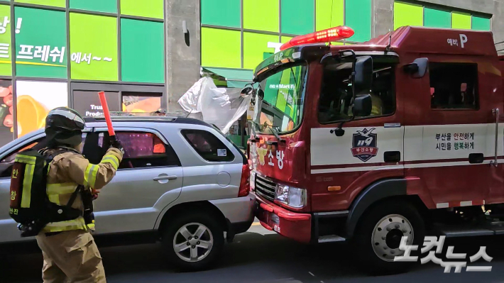 13일 부산 부산진구 한 도로에서 소방 펌프차가 불법 주차 차량을 가정한 SUV 차량을 밀어내며 전진하고 있다. 박진홍 기자