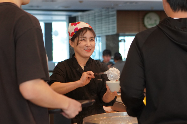 장윤정 셰프가 환하게 웃으며 학생들에게 음식을 건네고 있다. 한동대 제공