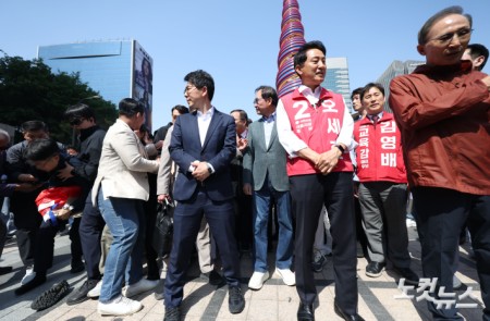 오세훈 국민의힘 서울시장 후보와 이명박 전 대통령이 15일 오전 서울 중구 청계광장에서 만나 대화하던 중 한 남성이 "용산참사 책임자"라고 외치며 달려들다 제지당하고 있다.