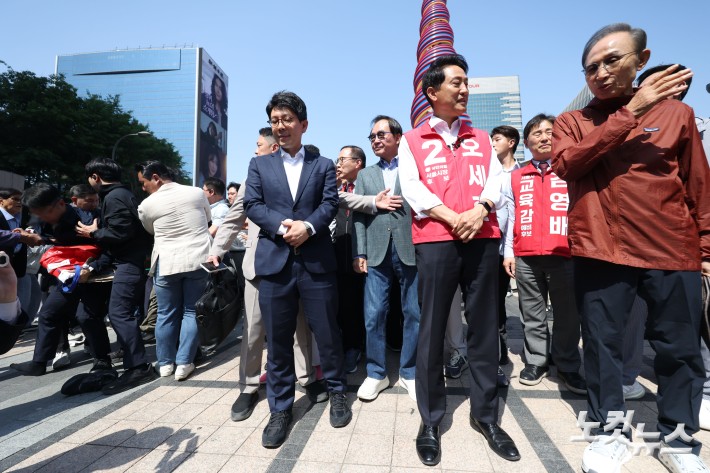 오세훈 국민의힘 서울시장 후보와 이명박 전 대통령이 15일 오전 서울 중구 청계광장에서 만나 대화하던 중 한 남성이 "용산참사 책임자"라고 외치며 달려들다 제지당하고 있다.