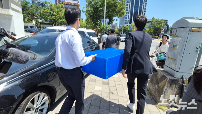 15일 이남호 전북교육감 후보의 선거사무소를 압수수색한 수사관들이 확보한 증거품 등을 들고 사무소를 떠나고 있다. 심동훈 기자