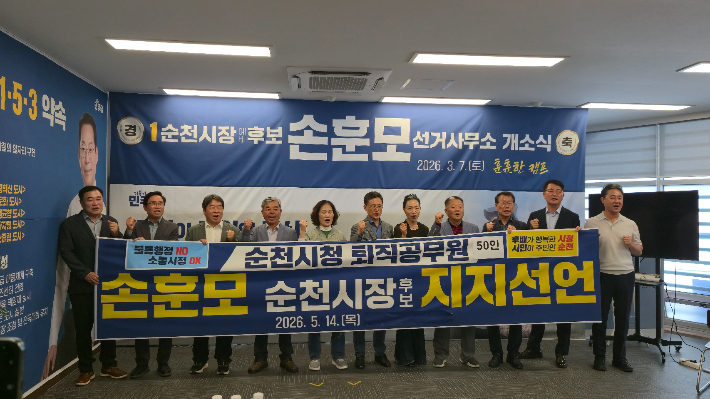 순천시청 앞에서 지지선언을 마친 퇴직 공무원들이 선거사무소를 찾아 현수막을 들고 기념촬영을 하고 있다. 손훈모 선거 캠프 제공 