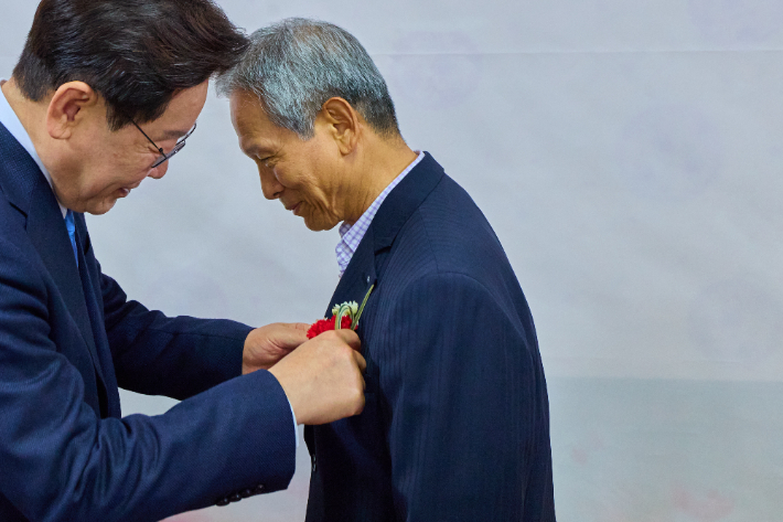 이재명 대통령이 경북 안동 한 식당에서 삼계초등학교 은사 박병기 선생님에게 카네이션을 달아드리고 있다. 청와대 제공