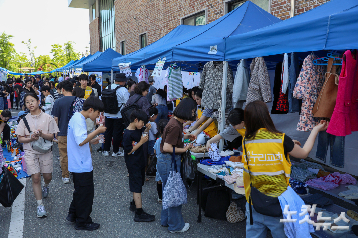 페스티벌 참가자들이 플리마켓에서 판매 중인 의류 물품을 살펴보고 있다. 최화랑 기자